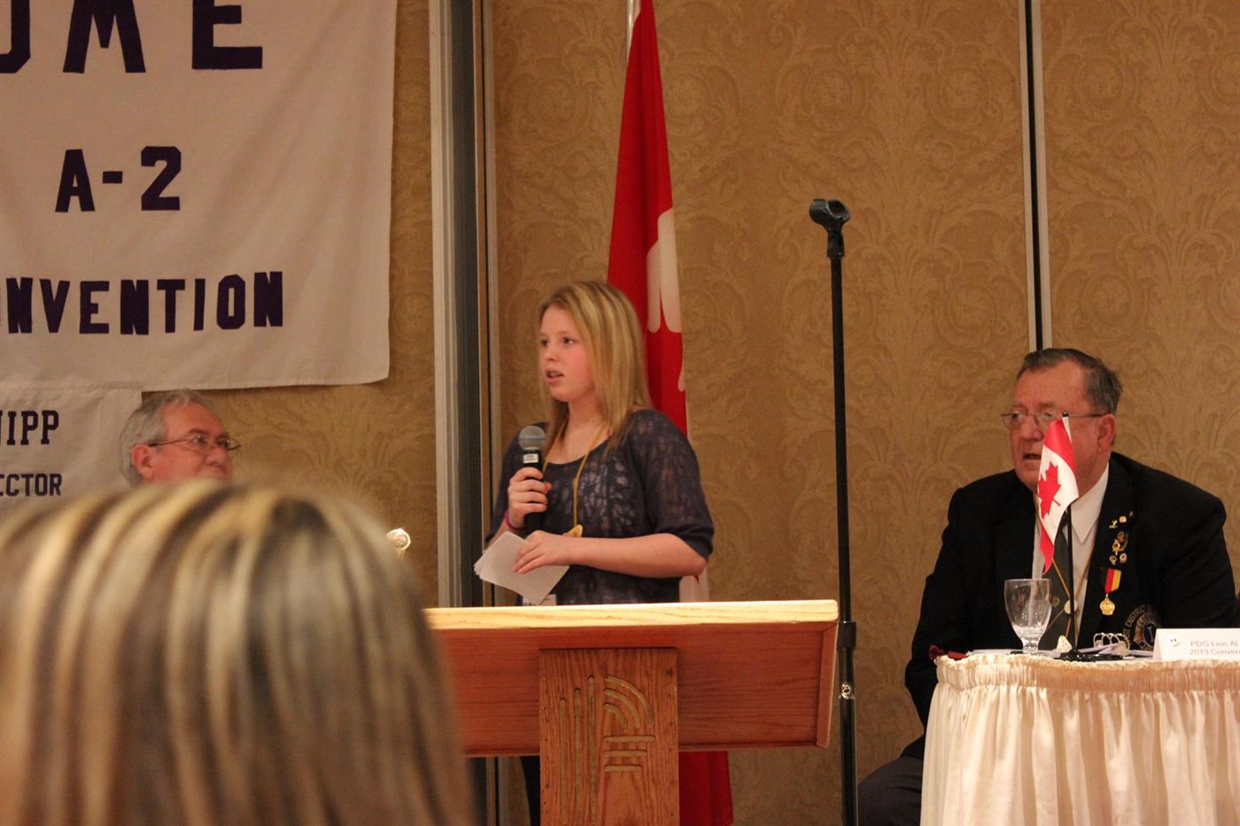 Annaleise Carr speaking from a wooden podium.